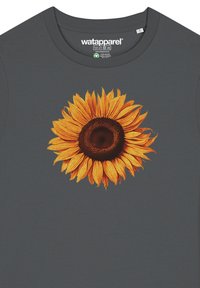 Grijze T-shirt met een grote zonnebloemafbeelding in geel en bruin. Zachte textuur, ronde halsontwerp en bedrukte details aan de voorkant.