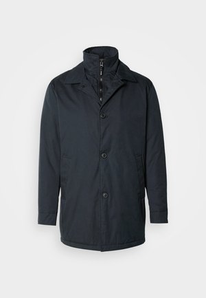 Marineblå jakke i vandafvisende stof med høj krave, to for- lommer, enkelknap lukning og en glat tekstur.