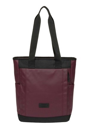 Bolsa tote burdeos y negra con asas largas negras, bolsillos laterales, bolsillo delantero con cremallera y parche rectangular con logo en el frente.