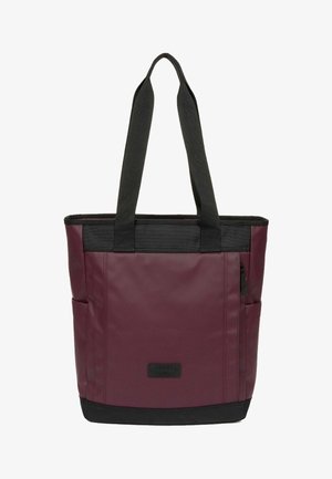 Bolsa tote burdeos y negra con asas largas negras, bolsillos laterales, bolsillo delantero con cremallera y parche rectangular con logo en el frente.
