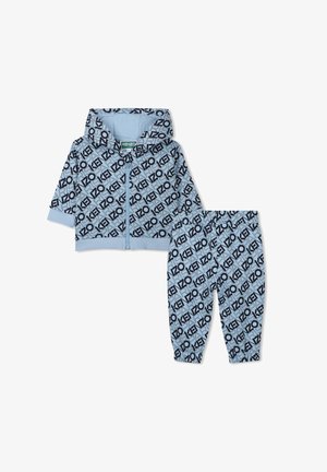 Sweat à capuche zippé bleu clair avec des motifs en logos noirs répétitifs, associé à un pantalon assorti. Tissu doux et coupe décontractée.