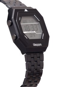 Digital klocka med ett oktagonalt svart hölje i resin och justerbart svart metallarmband. LCD-skärmen visar tid, datum och larmfunktioner.