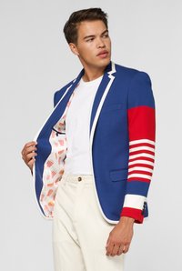Blauwe blazer met rood-witte gestreepte mouwen, witte afwerking en een patroon in de binnenkant met etenswaren zoals friet en worstjes.