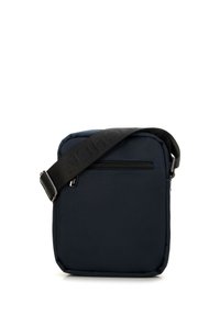 Borsa a tracolla blu navy con tessuto texturizzato, dotata di una tasca frontale con zip e di una tracolla nera regolabile. Forma quadrata con bordi morbidi.