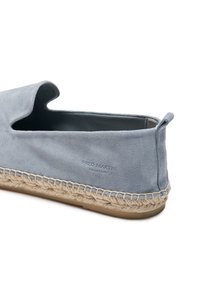 Zapato slip-on de ante azul con suela de cuerda de yute natural, que presenta una apertura redondeada y una sutil marca en el lateral.