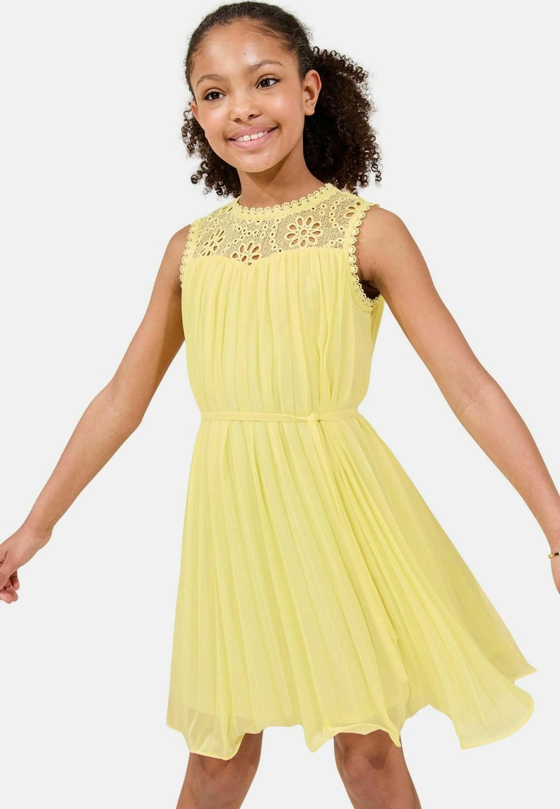Abito giallo plissettato con yoke in pizzo floreale, design senza maniche e cintura in vita. Il tessuto morbido e leggero crea una silhouette fluente.