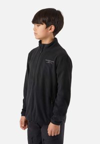 Čierna fleece bunda s vysokým golierom, celým zipsom a bočnými vreckami. Na ľavej strane na hrudi je biely nápis "Swedemount".