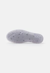 Translucent rubber outsole with textured grip pattern, rounded heel, and reinforced edges. Features embedded design elements.