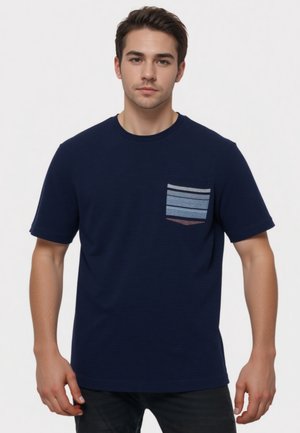 Camiseta de rayas marinas con cuello redondo, que presenta un bolsillo con rayas horizontales de azul claro y oscuro en el lado izquierdo. Diseño casual.