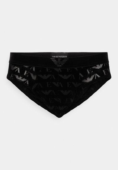 Črne hlačke z teksturiranim vzorcem logotipa Emporio Armani; imajo gladko elastiko in tesen fit. Material se zdi raztegljiv.