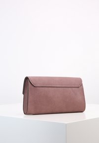 Różowa torebka kopertówka z faux skórki, z zapięciem na klapkę, prostokątnego kształtu, gładkiej tekstury i delikatnym przeszyciem wzdłuż krawędzi.