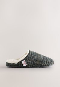 Mule homme à enfiler en tissu tweed vert foncé et gris avec une doublure en fausse fourrure blanche.