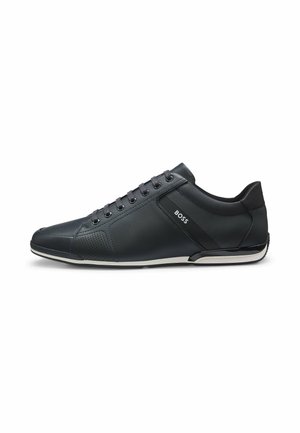 Zapatilla negra de piel de caña baja con cordones en la parte delantera, detalles perforados cerca de la puntera, ribete blanco en la suela y logotipo "BOSS" en el panel lateral.