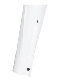 Chemise blanche à manches longues avec une broderie de rose noire sur le poignet, avec un accent de bouton en matériau foncé contrastant.