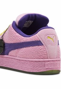 Roze textuur sneaker met paarse accenten, gemaakt van suede en stof, ronde vorm en een geel logo-detail.