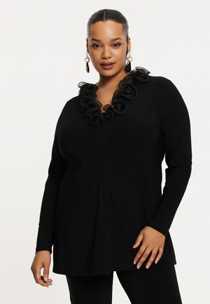 Zwart shirt met lange mouwen, voorzien van een gerimpelde halslijn en knoopsluiting aan de voorkant. Gladde textuur, aangesloten stijl en een verlengde zoom.