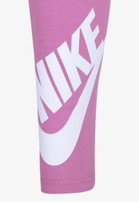 Rózsaszín Nike leggings, nagy fehér logóval. Sima, rugalmas anyag, testhez álló fazon és letisztult varrások.