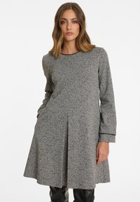 Graues Strickkleid mit langen Ärmeln, rundem Ausschnitt und ausgestellter Silhouette. Verfügt über eine subtile Textur und Seitentaschen; besetzter Saum.