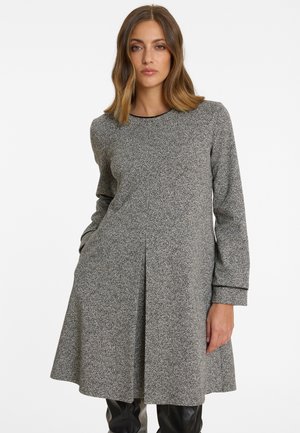 Robe en tricot grise avec manches longues, encolure ronde et silhouette évasée. Présente une texture subtile et des poches latérales ; détail de ourlet festonné.