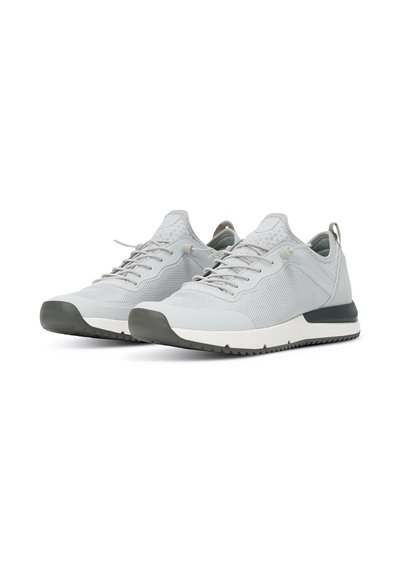 Baskets de sport gris clair avec tige en maille, détails texturés, semelle extérieure gris foncé contrastante et lacets. Design minimaliste avec tirette à l'arrière.
