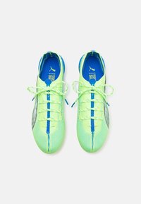 Scarpe da ginnastica verde lime con parte superiore testurizzata, accenti blu e dettagli riflettenti. Presentano lacci sottili e un design snello.