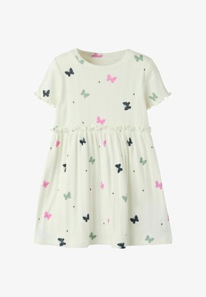 Biała dzianinowa sukienka z krótkim rękawem i falbaną w talii, zdobiona różowymi, czarnymi i zielonymi motylami rozmieszczonymi na tkaninie.