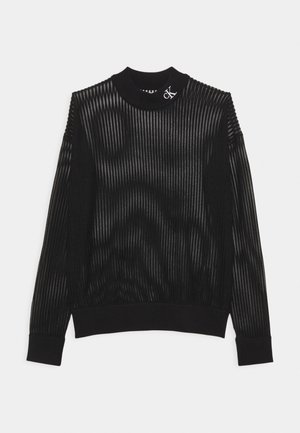 Czarny prążkowany sweter z długim rękawem i stójką, z małym białym logo "cK" na kołnierzu, prezentowany na białym tle.