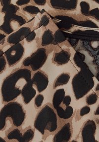 Leopardinprintti, jossa on suuria mustia laikkuja vaaleanruskealla taustalla, sileä pinta ja hienovarainen kiilto. Kankaan reuna näkyy.