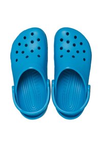 Zuecos azules hechos de plástico flexible, con múltiples perforaciones, una correa trasera elevada, plantilla texturizada y superficie lisa.