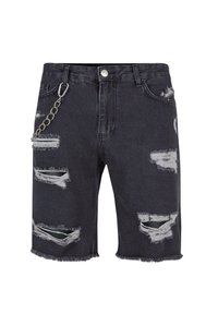 Shorts de mezclilla negra con un diseño desgastado, bordes deshilachados y múltiples rasgaduras. Incluye un detalle de cadena plateada en el lado.