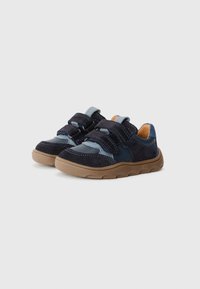 Blå och marinblå sneakers med kardborreband, ovansida i mocka och syntet, gummisula, vadderad krage och kontrasterande tan yttersula.