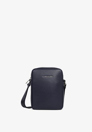 Sac bandoulière en cuir bleu marine avec une surface texturée, de forme rectangulaire, fermeture zippée et une marque discrète sur le devant. Sangle ajustable incluse.