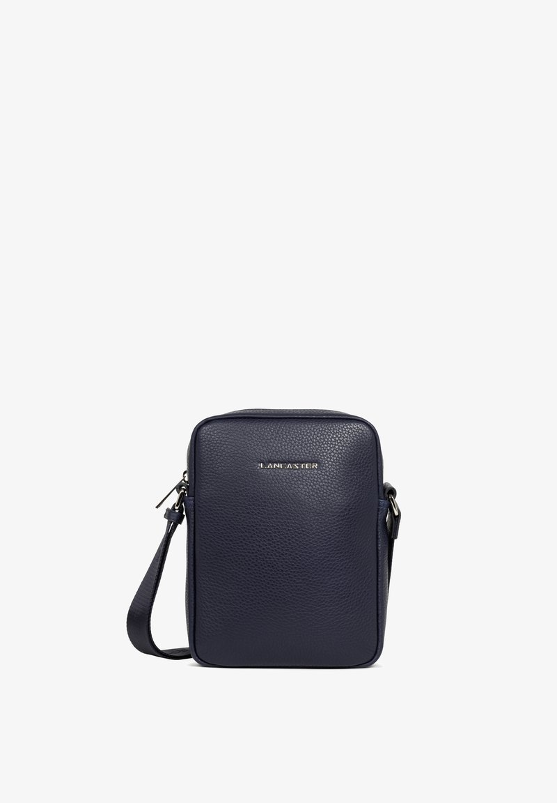 Sac bandoulière en cuir bleu marine avec une surface texturée, de forme rectangulaire, fermeture zippée et une marque discrète sur le devant. Sangle ajustable incluse.