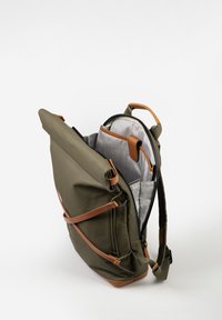 Zaino verde con chiusura a rotolo, con cinghie in pelle marrone, aperto per mostrare un vano imbottito per laptop e tasche interne con fodera a quadretti bianchi.