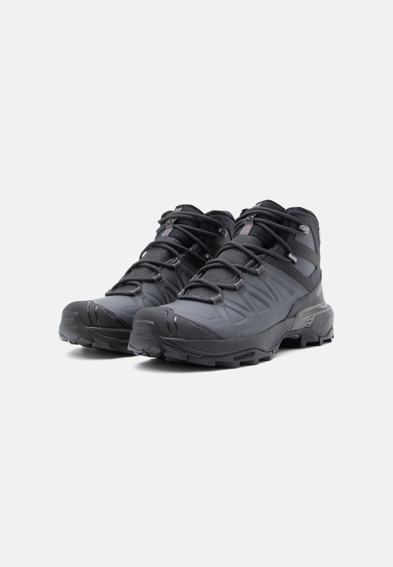Zwarte wandelschoenen met een gestructureerde synthetische bovenkant, in contrast met gladde rubberen accenten. Voorzien van meerdere vetersluitingen en een robuuste zool.
