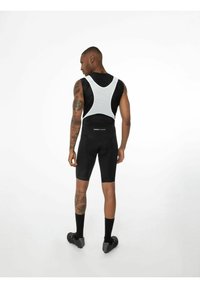 Schwarze Fahrradhosen mit enganliegendem Design, ausgestattet mit einem weißen Mesh-Oberteil und schwarzem Textilmaterial. Beinhaltet Akzentnähte und gepolsterte Details.