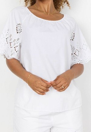 Witte katoenen blouse met een ronde halslijn, met geborduurde kanten afwerking op de mouwen. Gladde textuur, casual pasvorm en korte pofmouwen.