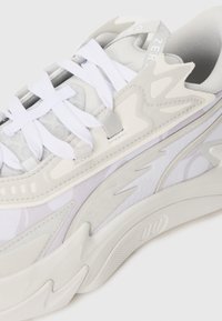 Light grey sneaker with a layered design, mesh and suede materials, white laces, and distinctive molded accents on the sole.