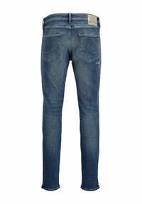 Blue denim jeans with a slim fit, featuring a smooth texture, two back pockets, and a label on the waistband.