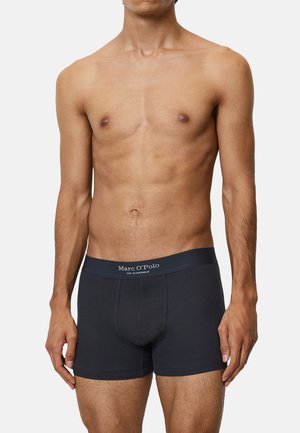 Dunkelblaue Boxershorts aus geripptem Baumwollstoff, mit einem weichen, elastischen Bund, der das Logo "Marc O'Polo" in weißer Schrift zeigt.