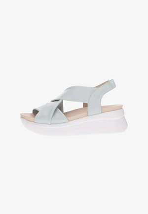 Sandali platform azzurro chiaro con fasce incrociate, suola in gomma e design aperto sulla punta. Texture liscia con una leggera lucentezza. Stile minimalista.