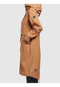 Impermeabile marrone con cappuccio, realizzato in materiale resistente all'acqua. Presenta coulisse regolabili, tasche con zip e una patch con il logo sulla manica.
