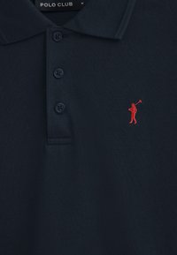 Mörkblå polotröja i textilmaterial. Har en treknapps-knäppning och en liten röd broderad figur som håller i en golfklubba.