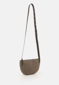 Borsa a tracolla in suede marrone con chiusura a zip, forma curva, tracolla regolabile e texture liscia. Design semplice senza parti metalliche visibili.