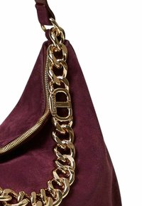 Borsa a spalla in suede bordeaux con tracolla in catena dorata, con chiusura a zip e forma arrotondata, che enfatizza la texture e i dettagli di lusso.