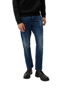 Ciemnoniebieskie, proste dżinsy z delikatnym przetarciem, w połączeniu z czarnym swetrem i czarnymi butami na sznurówki. Casualowy i funkcjonalny design.