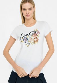 Hvid kortærmet T-shirt med farverigt blomstermotiv og "Liu Jo" branding i en stilfuld, skrå skrifttype. Blødt bomuldsstof.