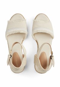 Sandali espadrilles beige con cinturini in tessuto testurizzato, dettagli con frange, chiusura con fibbia in metallo e una soletta morbida. Design con tacco piatto.