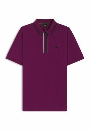 Polo shirt violet à manches courtes, avec un zip sur le col, logo noir et détails rayés contrastants sur la fermeture éclair. Texture lisse et coupe moderne.