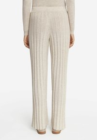 Beżowe, żeberkowe spodnie dzianinowe w szerokim fasonie, z pionowymi paskami i wygodnym, elastycznym pasem.